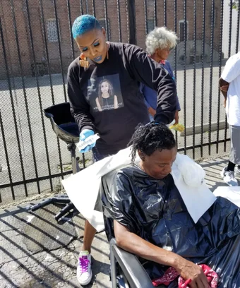 Raines uses camping and salon equipment to do hair without a water source.